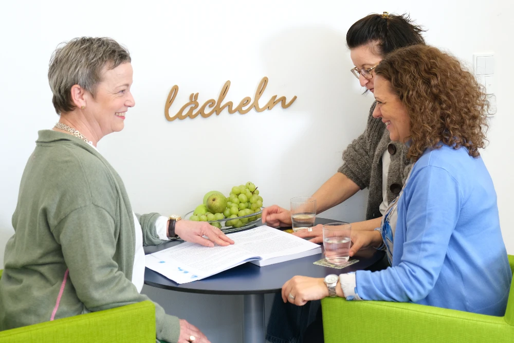 Steuerberaterin Sabine Thieler im Arbeitsgespäch mit zwei Mitarbeiterinnen.